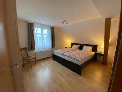 sypialnia z łóżkiem, krzesłem i oknem w obiekcie Bodensee Wohnung 3 mit Privatstrand w mieście Gaißau