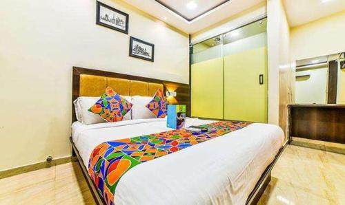a bedroom with a large bed with a colorful blanket at FabHotel Ascot International II in Mumbai