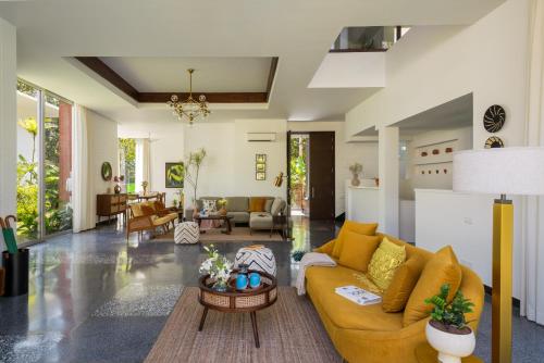 a living room with a couch and a table at La Macedo, Luxury 3 BHK Villas in Assagao, with Private Pool, Garden, Terrace, Parking, Security in Mapusa