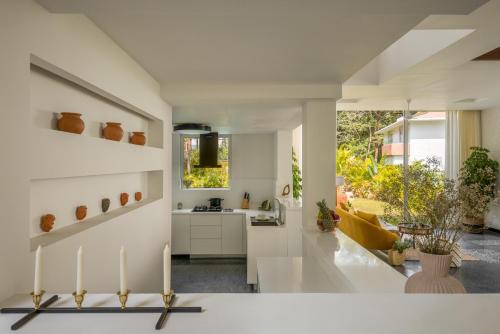 a white kitchen with a sink and a counter at La Macedo, Luxury 3 BHK Villas in Assagao, with Private Pool, Garden, Terrace, Parking, Security in Mapusa