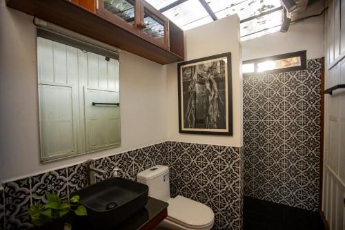 a bathroom with a toilet and a picture on the wall at Khmer Oasis on the Lake 