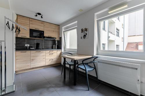 une cuisine avec une table et des chaises et une fenêtre dans l'établissement Résidence le premium, hyper centre, studio tout équipé, à Strasbourg