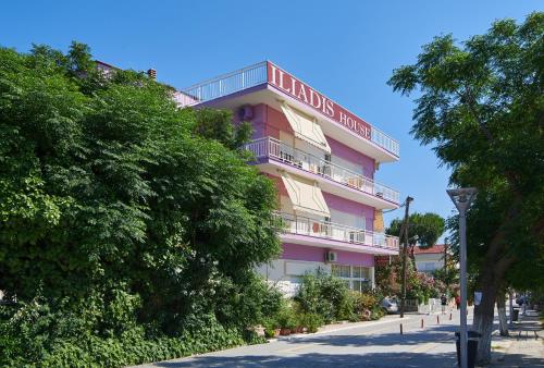 a pink building with a sign on it at Iliadis House in Sarti