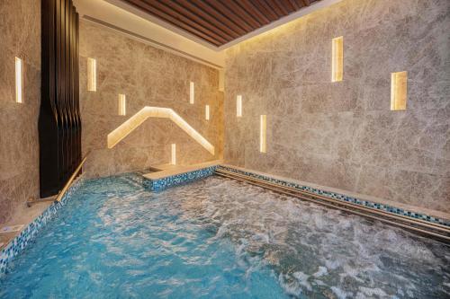 a large swimming pool in a room with a swimming pool at Studio City - Epic Tower in Macau