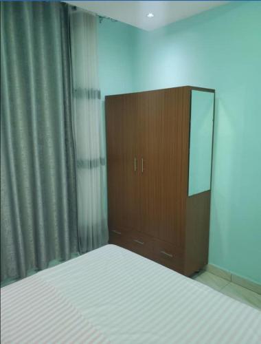 1 dormitorio con 1 cama y vestidor con espejo en IP House en Kigali