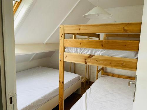ミッデルケルケにあるPretty little house full of charm, located in a green and peaceful setting, very close to seaの屋根裏部屋の二段ベッド2台