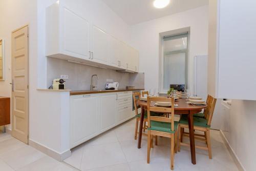 a kitchen with a wooden table and a dining room at Bartók Boulevard Apartment by NW in Budapest