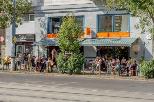 a group of people sitting outside of a restaurant at Bartók Boulevard Apartment by NW in Budapest