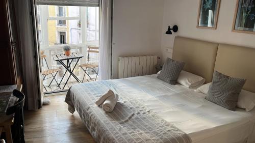 una camera da letto con un letto e un asciugamano sopra di Pension Boutique Doña Urraca a Burgos
