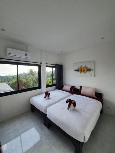 two beds in a room with two dogs on them at duplex 2 bedroom sea view villa with private pool in Koh Samui