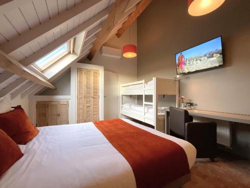 a bedroom with a large bed and a flat screen tv at Hotel - B&B PassaDia in Zwevegem