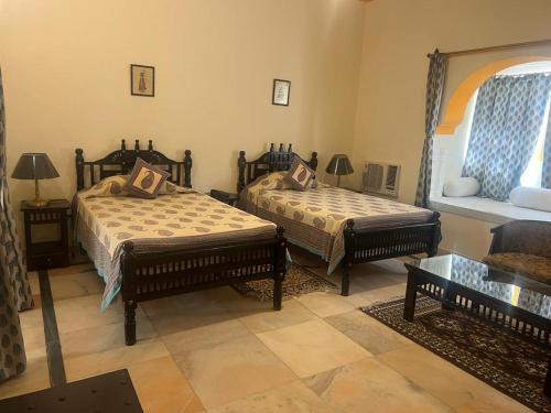 uma sala de estar com duas camas e um sofá em hotel castle alsisar em Alsīsar