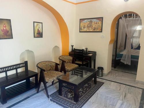 uma sala de estar com cadeiras e mesas num quarto em hotel castle alsisar em Alsīsar