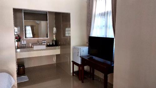 a bathroom with a sink and a desk and a mirror at Grand Melka Hotel in Lovina