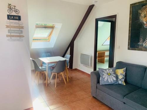 un salon avec un canapé et une table dans l'établissement Appartement situé prés des plages et du golf, à Saint-Briac-sur-Mer