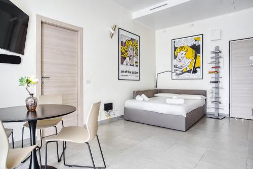 um quarto com uma cama, uma mesa e uma sala de jantar em JOIVY Welcoming Studio near CityLife em Milão