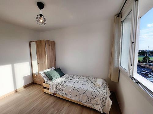 a small bedroom with a bed and a window at Appartement Spacieux et Rénové in Neuilly-sur-Marne