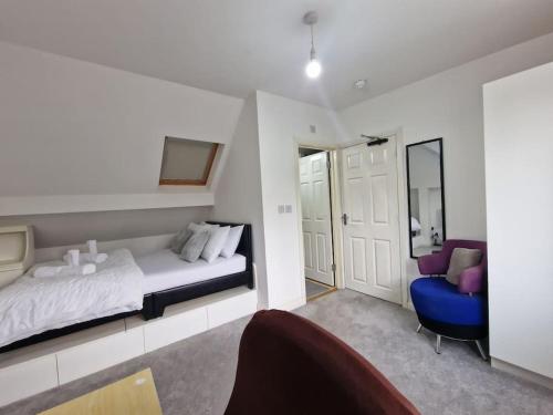 een slaapkamer met een bed en een blauwe stoel bij Nice Living Serviced Accommodations 9 (King-Size Studio Flat + Kitchen) in Coventry