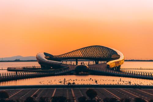 a group of buildings with a sunset in the background at Le Meridien Suzhou, Suzhou Bay in Suzhou