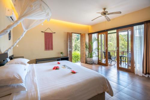 sypialnia z dużym łóżkiem z kwiatami w obiekcie Lembeh Resort w mieście Bitung