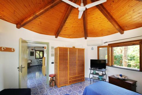 a room with a ceiling fan and a living room at BOUTIQUE VILLA con accesso privato alla spiaggia in Caronia