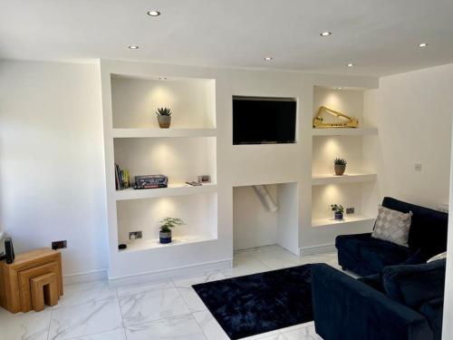 een woonkamer met een bank en een flatscreen-tv bij Modern bungalow in good location in Aberdulais