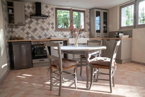 a kitchen with a table and chairs in it at Charmant Appartement T2 Parking & Terrasse - Crêt de la Roche in Aix-les-Bains