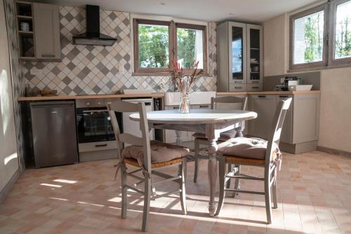 een keuken met een tafel en stoelen. bij Charmant Appartement T2 Parking & Terrasse - Crêt de la Roche in Aix-les-Bains