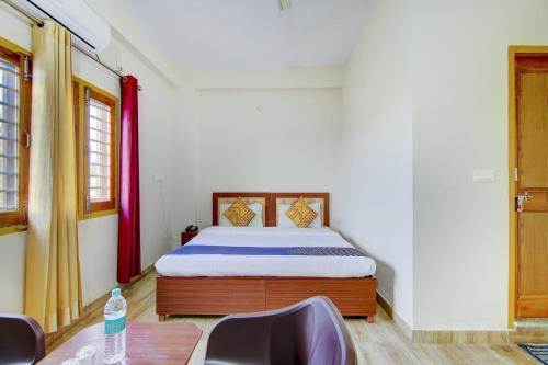 1 dormitorio con 1 cama, mesa y sillas en SPOT ON Chandra's Residence, en Dehradun
