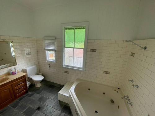 La salle de bains est pourvue d'une baignoire, de toilettes et d'un lavabo. dans l'établissement Neat, Tidy and Central, à Brisbane