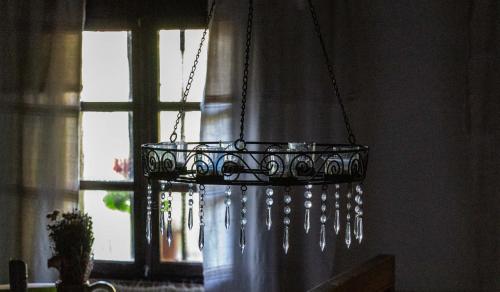 a chandelier is hanging in front of a window at Fecskefészek Vendégház Őriszentpéter in Őriszentpéter