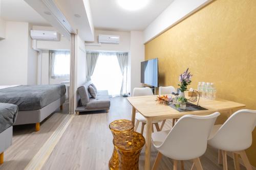 a room with a bed and a table and chairs at Ocean Tsutenkaku in Osaka
