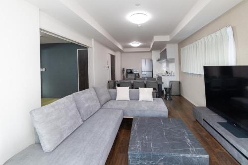 a living room with a couch and a flat screen tv at Ocean Tsutenkaku in Osaka