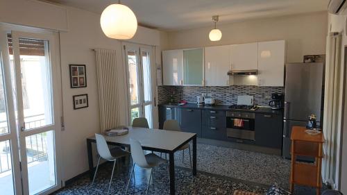 una cucina con tavolo, sedie e frigorifero di Apartment Obici a Spilamberto