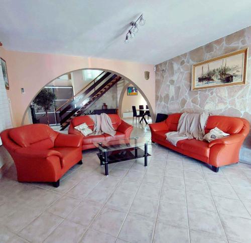 a living room with red couches and a stone wall at Holiday home in Skrip/Insel Brac 5973 in Škrip