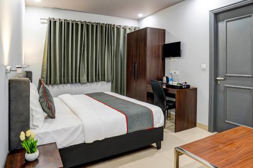 um quarto de hotel com uma cama, uma secretária e uma mesa em Super Townhouse 1263 Shalimar Residency Near Shalimar Bagh Metro Station em Nova Deli
