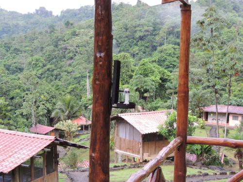 a group of houses with mountains in the background at Pacuare River Lodge in Bajo Tigre