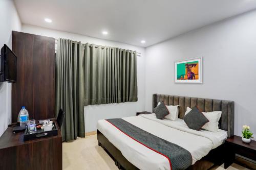 um quarto de hotel com uma cama e uma secretária em Super Townhouse 1263 Shalimar Residency Near Shalimar Bagh Metro Station em Nova Deli