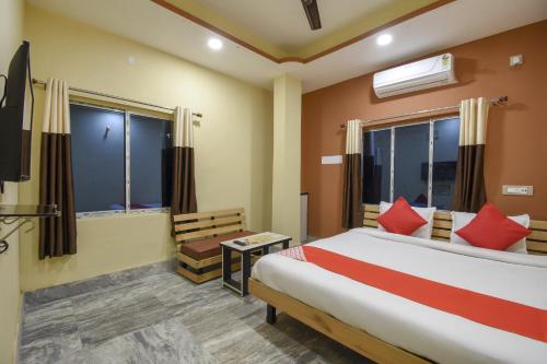 GauripurにあるFlagship Hotel Palki Palace Near Netaji Subhash Chandra Bose International Airportのベッドルーム(赤い枕のベッド1台、テレビ付)