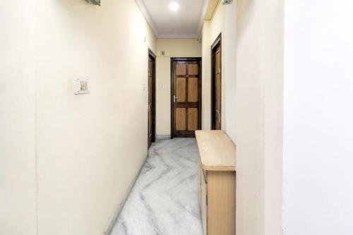um corredor com paredes brancas e uma secretária de madeira em SPOT ON Hotel Sanskriti em Nagpur