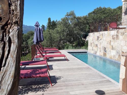 a row of lounge chairs next to a swimming pool at U Castellu, l' hôtel particulier in Propriano