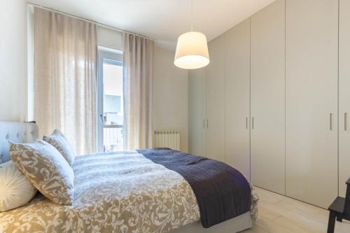 1 dormitorio con cama y ventana grande en Appartamento Garbino Deluxe - MyHo Casa, en Marina Palmense