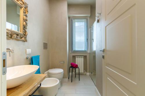 y baño con lavabo, aseo y espejo. en Appartamento Garbino Deluxe - MyHo Casa, en Marina Palmense