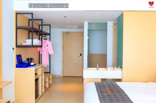 uma casa de banho com uma cama, um lavatório e um espelho. em Victor Group Condotel Cam Ranh em Cam Lâm