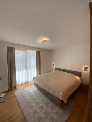 a bedroom with a bed and a large window at Berghof in Saas-Fee