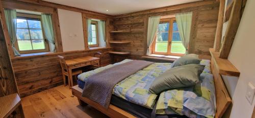 um quarto com uma cama num chalé de madeira em Ferme à Marius em Champéry
