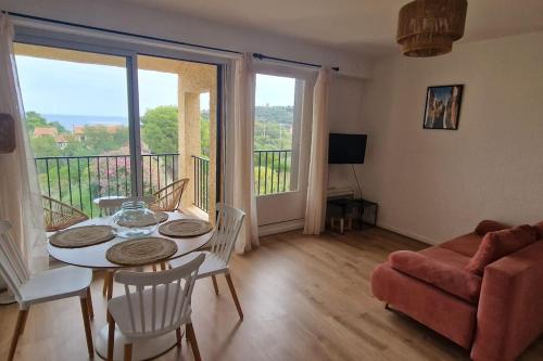 un salon avec une table et des chaises et un balcon dans l'établissement Charmant T2 au calme avec vue mer, proche centre de Collioure et parking, à Collioure