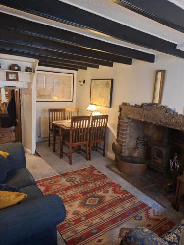 een woonkamer met een tafel en een open haard bij The Cottage, High Street Staithes in Staithes