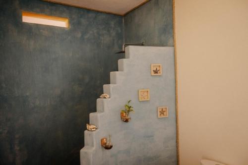 a staircase in a room with a blue wall at Casa Jasmin Bed & Breakfast in Troncones