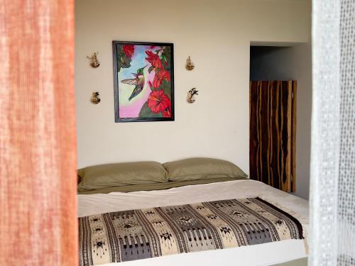 a bed in a bedroom with a picture on the wall at Casa Jasmin Bed & Breakfast in Troncones